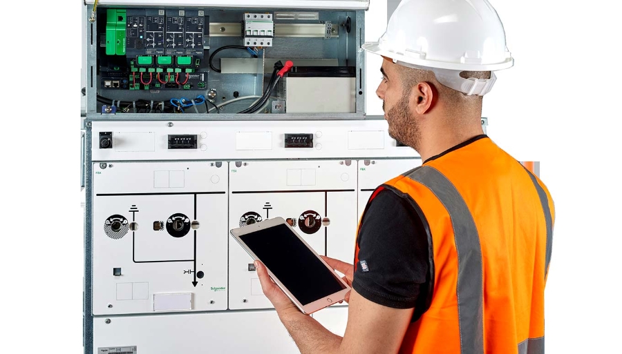 technician with digital tablet monitoring the performance of FBX, gas-insulated ring main unit 