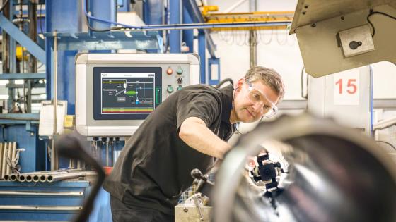 Worker using machinery in factory