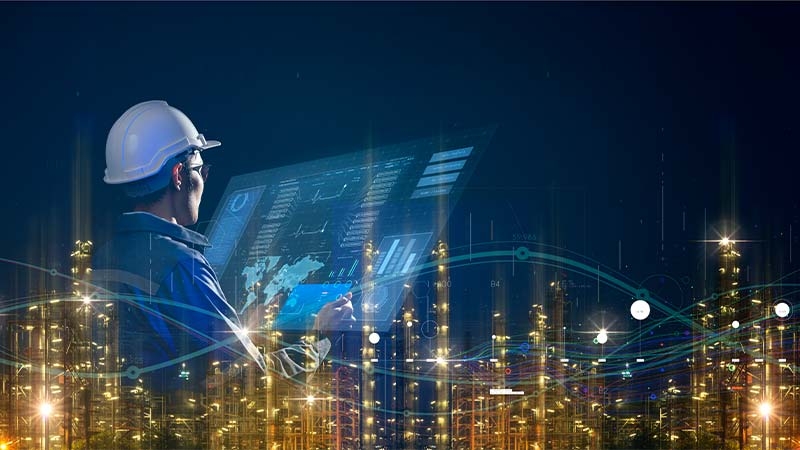 A person wearing a hard hat and holding a tablet