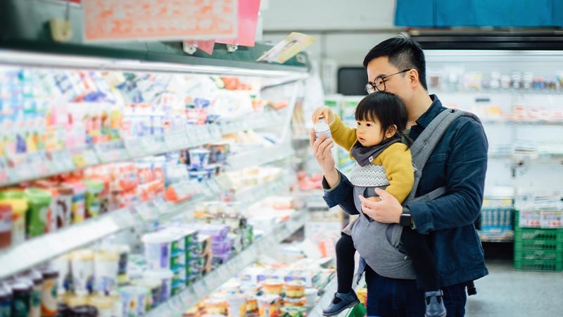 A person holding a baby in a baby carrier