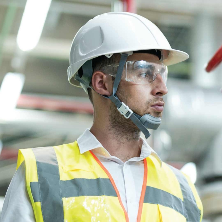 A portrait shot of an engineer wearing hard hat and protective clothing