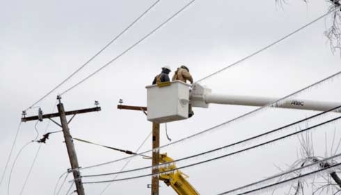 Electricistas trabajando para restablecer el suministro eléctrico, distribución de alimentación eléctrica.