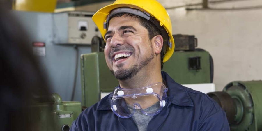 Smiling industrial production contractor holding a smartphone