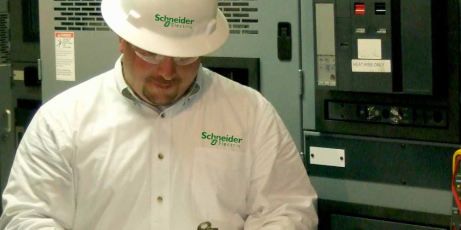 A Schneider Electric employee looking at a clipboard for energy management