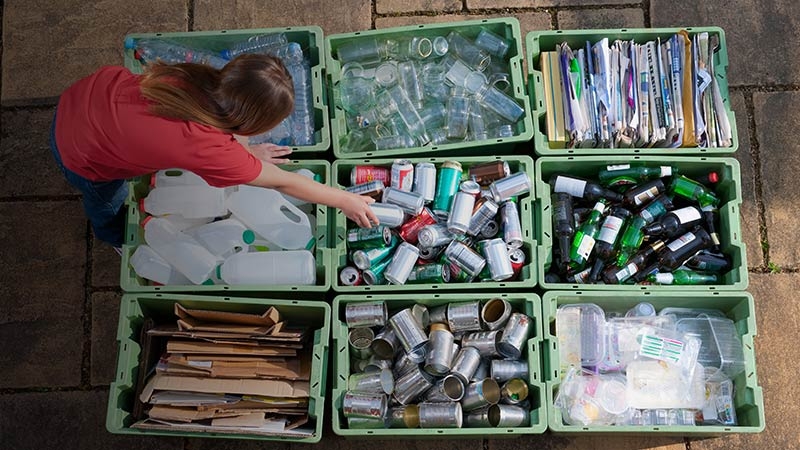 A girl sorting recyclable waste in different crates