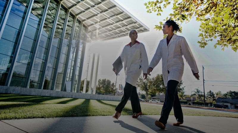 two ladies walking in front of office