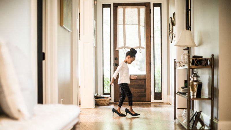 The child is playing while wearing her mother's heals