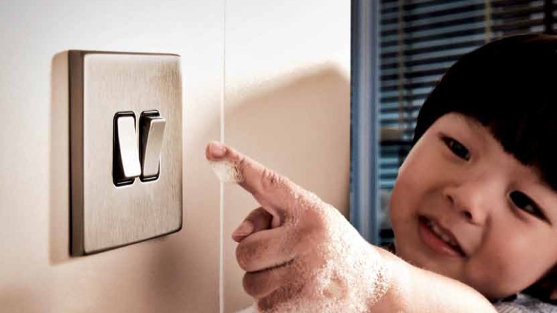 kid is switching off the swich with her wet finger 