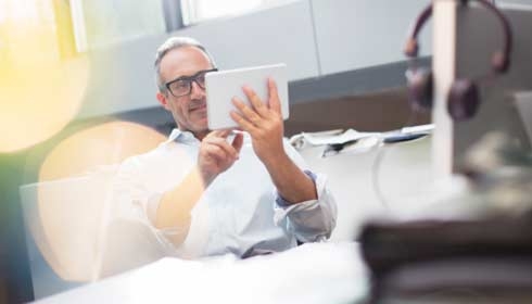 Businessman using digital tablet at office desk