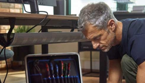 man and woman at desk separated by plastic glass