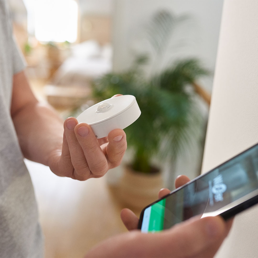 an electrician installing wiser motion sensor in smart home