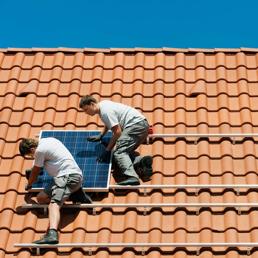 people on the roof attaching solar panel