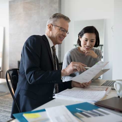 Financial advisor and woman with laptop meeting in dining room