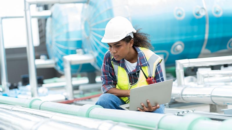 A person in a hard hat using a computer