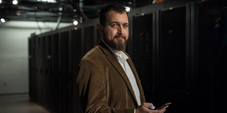 Product shot of a man standing in front of the IT server room.