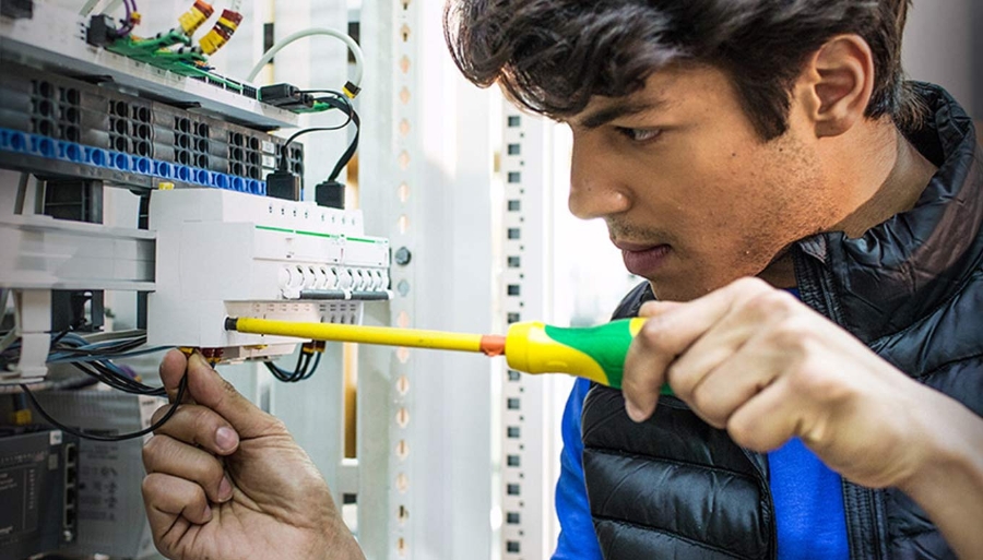 A young electrician installing an electrical device