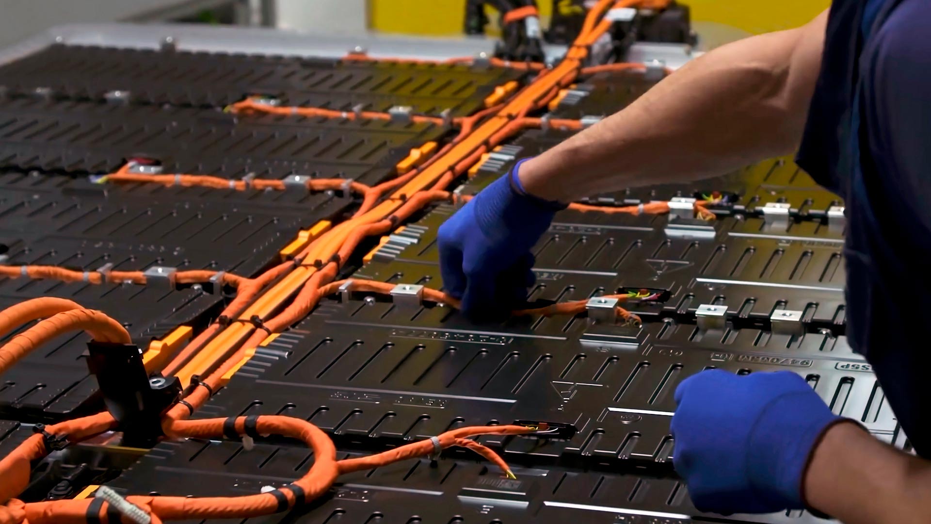 worker assembling electric vehicle batteries