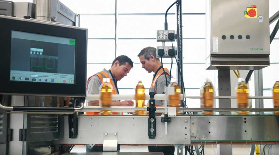 Factory workers in bottling plant,  food and beverage, manufacturing execution system.