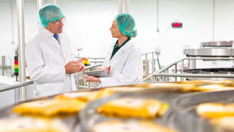 two lab workers talking to each other