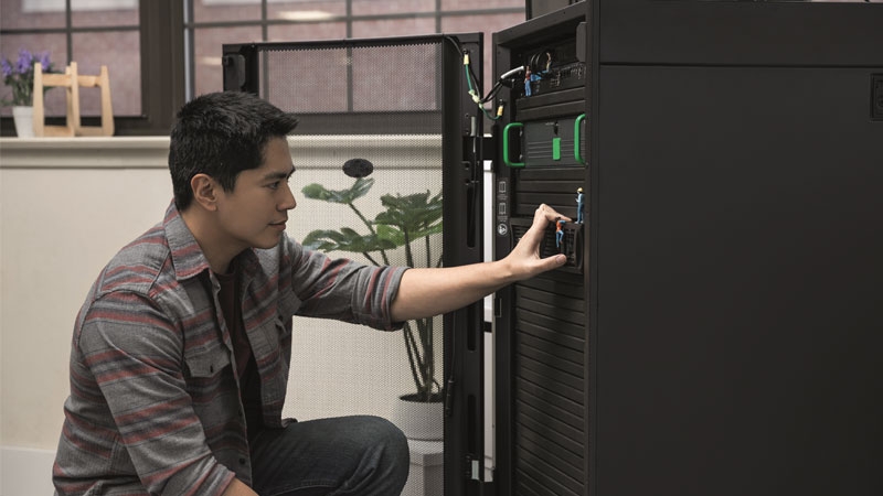 Man looking at micro data center image for HVC Buyers Guide to Edge Infrastructure Management