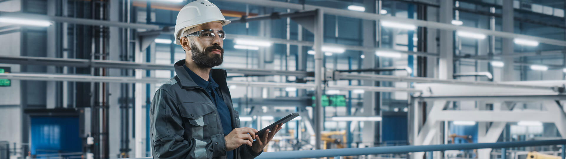 Car factory engineer in work uniform using tablet computer