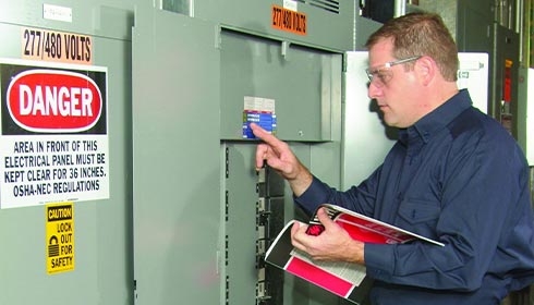 A person holding a book and pointing at a piece of paper