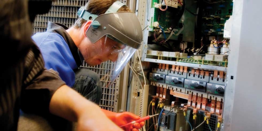 Technicians with face shields are working on servers, data center services.