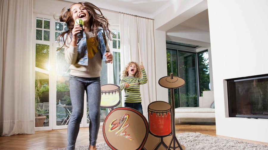 Two little girls playing drum in their house