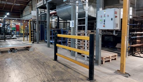 A yellow and black metal railing in a factory