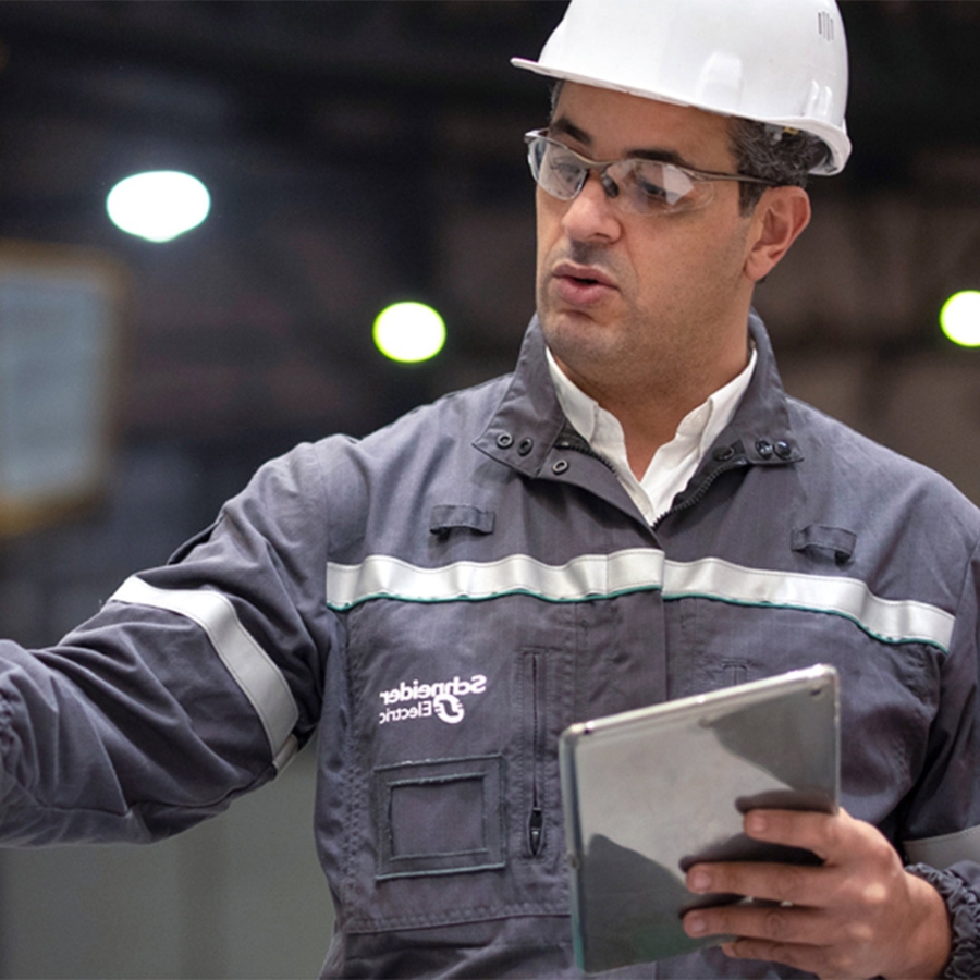 man wearing hardhat using a tablet