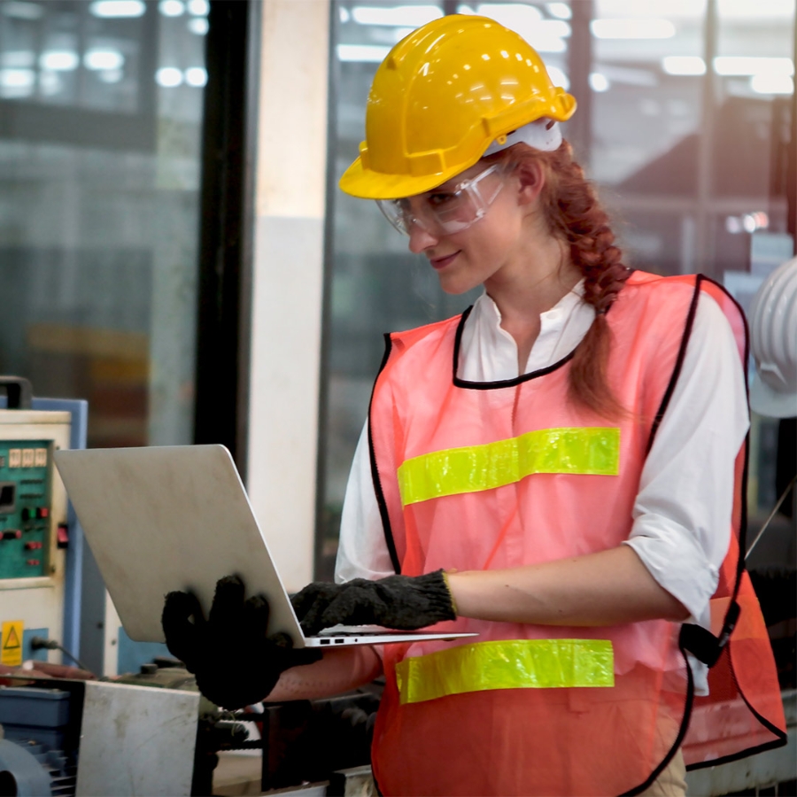 woman wearing hardhat using a laptop