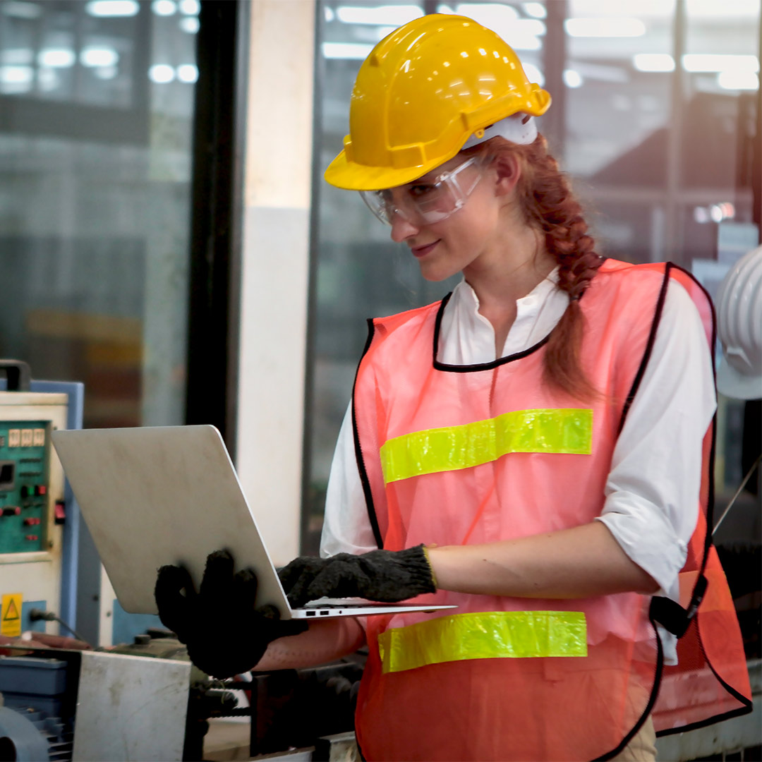 woman wearing hardhat using a laptop
