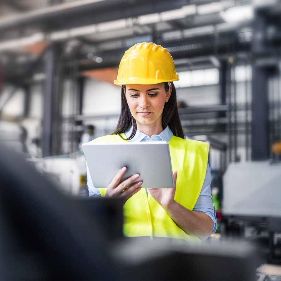 woman wearing hardhat using a laptop