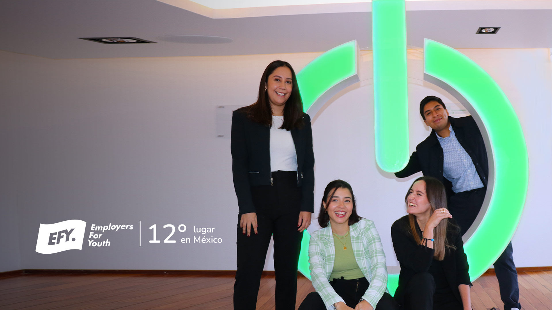 A group of employees at Schneider Electric Office beside big Life is On logo