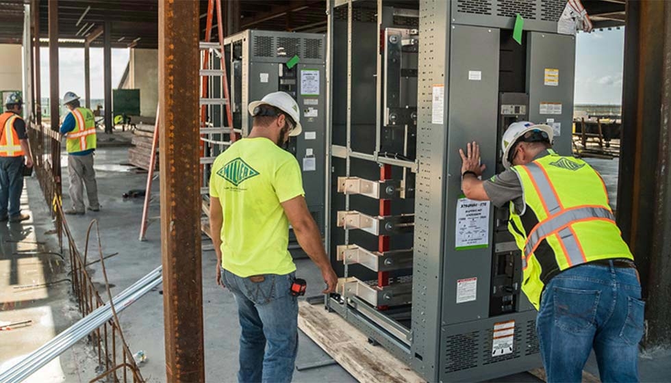 Two men working on the installation of a QED-2 Switchboard