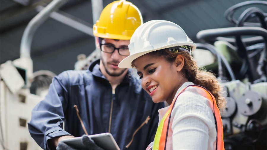 a man and woman in hardhats looking at table