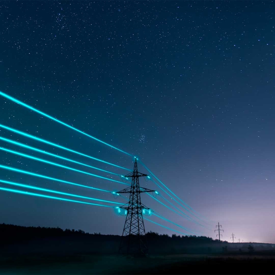 Electricity transmission towers with glowing wires against the starry sky. Energy concept.