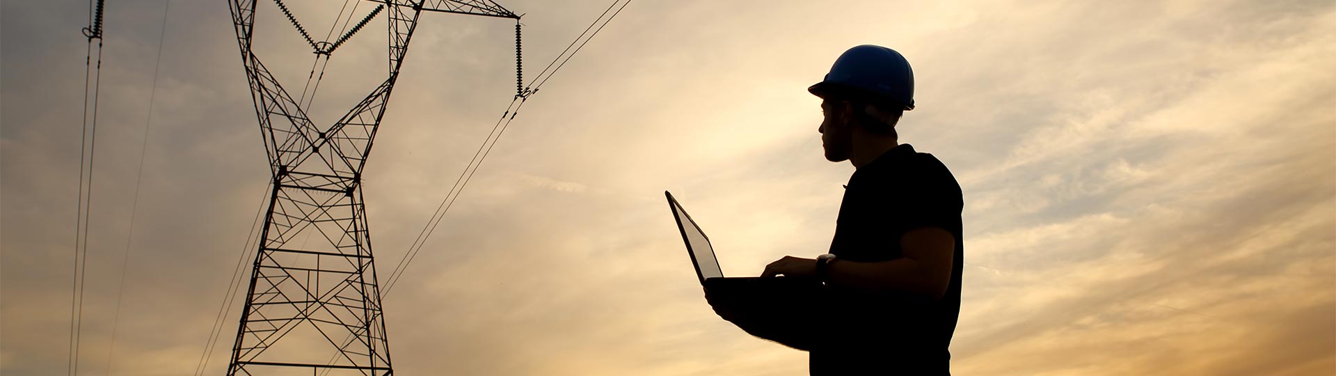 A person in a hard hat holding a computer