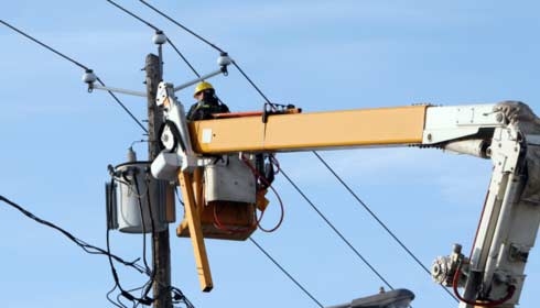 Electrician working on transformer, electrical power distribution.