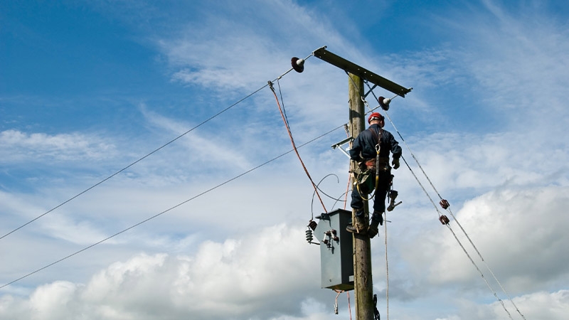 A person climbing a power line