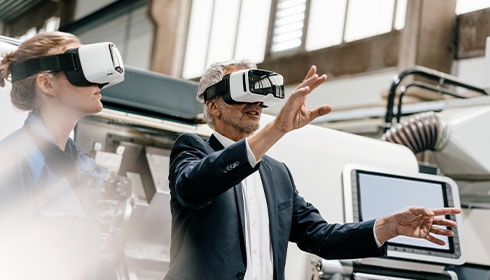 Businessman and skilled worker in high tech enterprise, using VR glasses