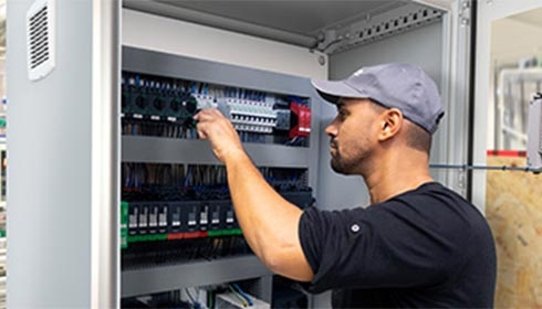 A person in a cap working on a machine