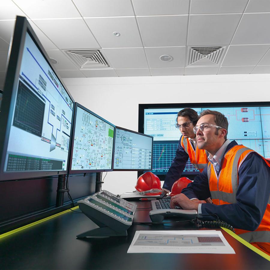 Operators in controlekamer van energiecentrale werken met technische uitdagingen, duurzaamheidsrapportage.