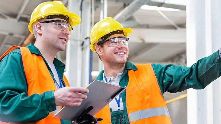 two man having tablet talk to each other in factory