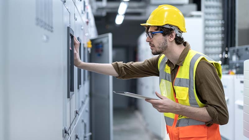 A person wearing a yellow hard hat and safety vest