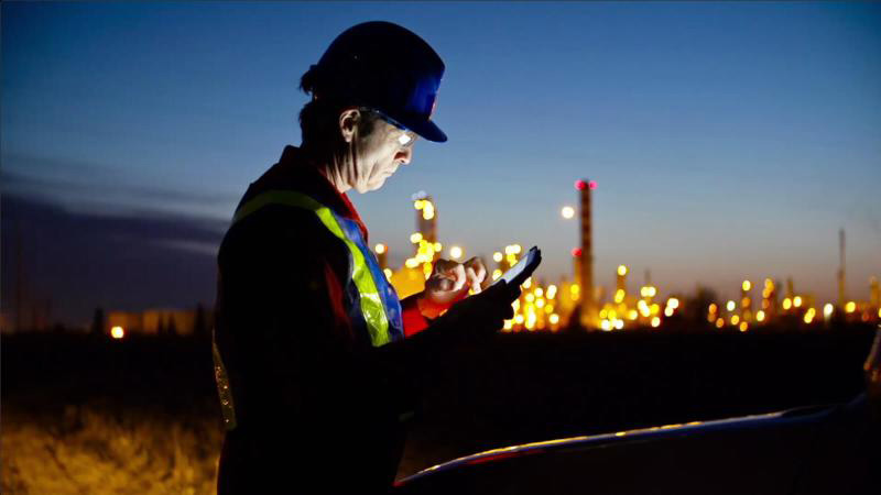 a man with a tablet in front of the facility