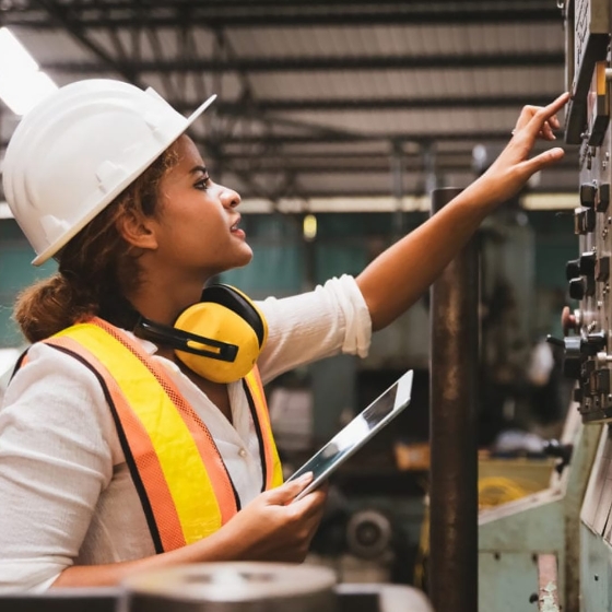 A female engineer checking the control panel at a factory