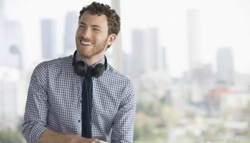 Happy businessman with digital tablet and headphones