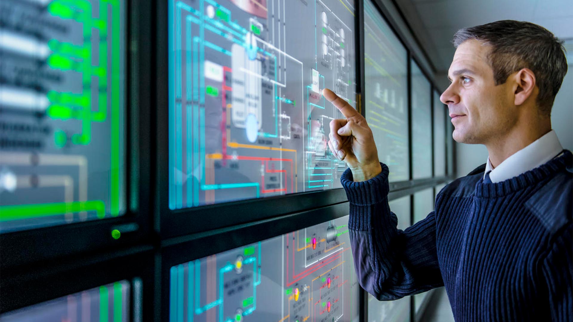 Gestor de instalações a utilizar o software de monitorização de energia numa visualização de vários ecrãs, gestão de energia industrial.