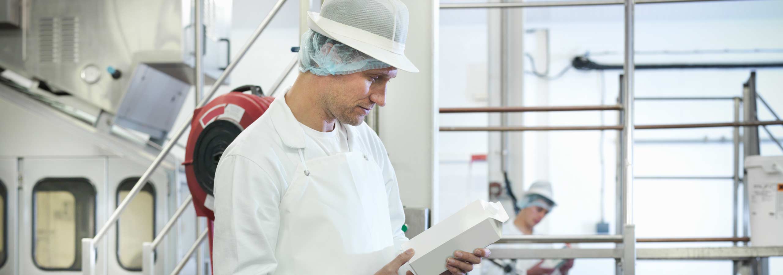 Worker inspecting goats milk in dairy, food and beverage, machine control.